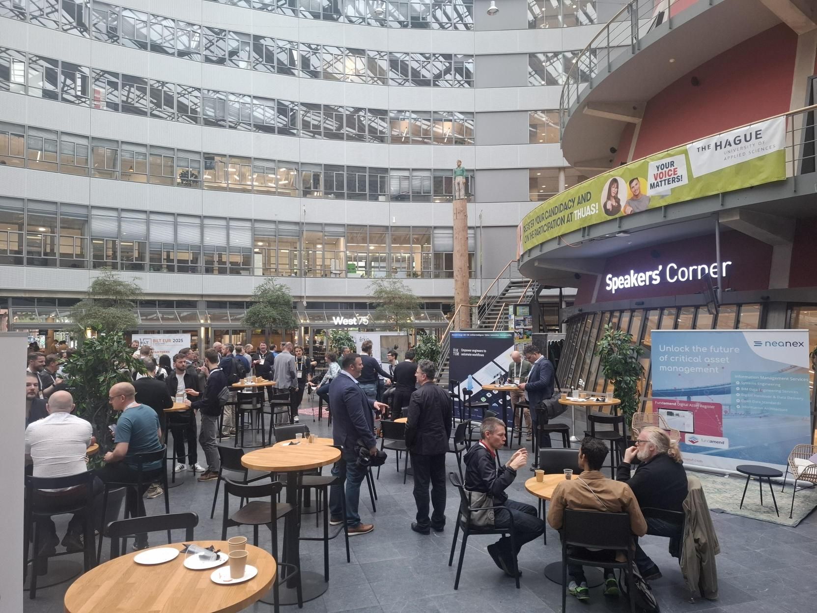 BILT Europe attendees networking in the venue atrium near the Speakers' Corner